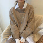 Oversized vest met v-hals en knopen voor dames, gedragen over een effen top en een jeans