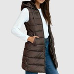 Gewatteerde dames bodywarmer met diepe zakken, gedragen over een trui in het tussenseizoen