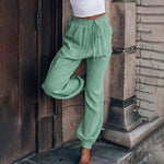Elegante saliegroene broek met koord in de taille en toelopende pijpen met elastische enkels
