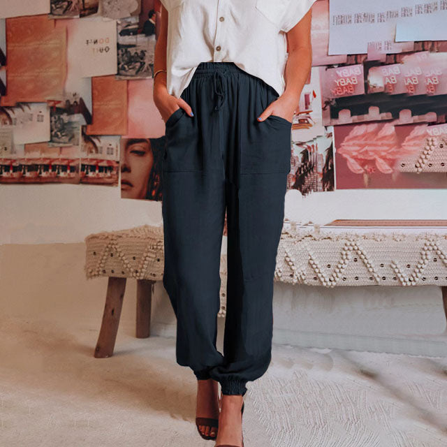 Elegante saliegroene broek met koord in de taille en toelopende pijpen met elastische enkels