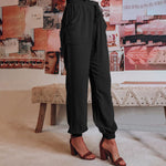 Elegante saliegroene broek met koord in de taille en toelopende pijpen met elastische enkels