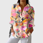 Lichte damesblouse met kleurrijke print en ruime pasvorm, los gedragen over een broek