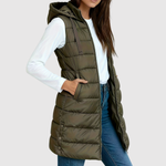 Gewatteerde dames bodywarmer met diepe zakken, gedragen over een trui in het tussenseizoen