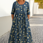 Ontspannen midi jurk met gele en witte bloemenprint op een blauwe ondergrond