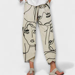 Elegante beige damesbroek met artistieke gezichtsprint, losse pasvorm en elastische tailleband