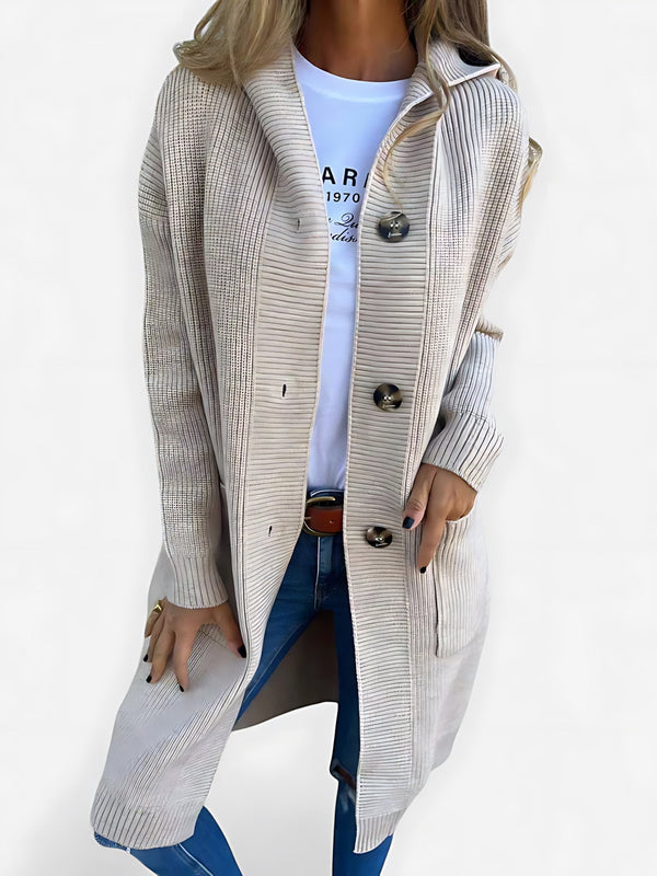 Lang gebreid vest met knoopsluiting voor dames, gedragen over een effen top en een jeans