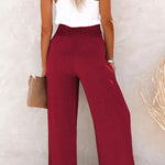 Relaxte broek met hoge taille, wijde pijpen en subtiele knopen in een neutrale tint