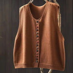 Mouwloos gebreid vest met knopen voor dames, gedragen over een effen top en een jeans